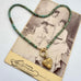A heart-shaped turquoise bead necklace with a gold heart pendant, displayed on top of a vintage photograph card.