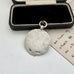 Vintage silver watch fob on a white surface