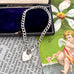 Silver bracelet with heart charms on a vintage-style card with text and an angel illustration.
