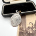 Vintage 1957 silver watch fob on an old jewellery box and photo