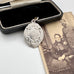 Vintage 1957 silver watch fob on an old jewellery box and photo