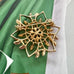 Vintage 1962 Sarah Coventry 'Peta-Lure' gold openwork flower brooch (Rare GB Mark) on a green fabric background