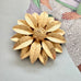 Vintage 1964 Sarah Coventry "Satin Petals" sunflower brooch with rare Canada mark on the cover of a Vogue book