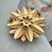 Vintage 1964 Sarah Coventry "Satin Petals" sunflower brooch with rare Canada mark on the cover of a Vogue book