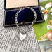 Vintage silver bracelet with heart-shaped lock charm in an open jewelry box on vintage paper.