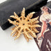 Vintage 1968 Sarah Coventry Cosmopolitan sunflower brooch on an old jewellery box and with an old postcard