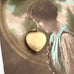 Vintage 9ct gold lined heart locket with gemstone on an old postcard