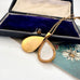 Vintage Handley Australian mid century gold fill teardrop pendant necklace on a floral card with a jewelry box in the background