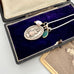 Vintage Infant of Prague charm necklace  in an open jewelry box on a white background