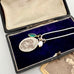 Vintage Infant of Prague charm necklace  in an open jewelry box on a white background