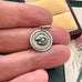 Vintage Uno A Erre silver Aries charm on an old jewellery box and in a womans hand
