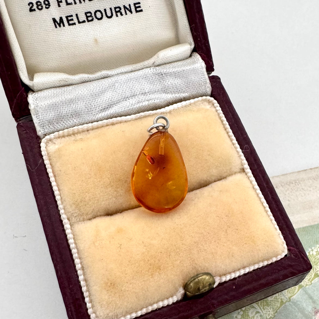 Teardrop-shaped amber pendant in a jewelry box with '289 Flinders Street Melbourne' text.