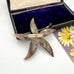 Vintage black mother of pearl brooch in an open box with a floral card in the background