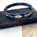 Decorative blue cloisonee bangle with floral patterns on a black background