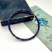 Blue cloisonne bangle on an old jewellery box and with a postcard with floral design