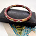 Vintage brown cloisonne bangle on an old jewellery box and with a vintage Christmas card
