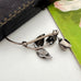 Vintage Danish John Lauritzen silver leaf and rose brooch on a white surface and with a vintage postcard and jewellery box