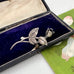 Vintage Danish John Lauritzen silver leaf and rose brooch on a textured black surface