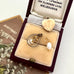 Jewelry box with gold heart pendant, gold and pearl pendant and a pearl in an open jewellery box