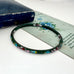 Vintage green cloisonne bangle on an old floral postcard and jewellery box