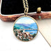 Vintage hand painted scene of Rapallo on the Italian riviera. A pendant on a chain leaning on an old jewellery box.