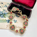 Vintage micro mosaic bracelet with floral designs in a jewelry box on a floral vintage postcard.
