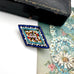 Vintage micro mosaic brooch on a floral-patterned fabric background