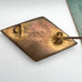 Back of vintage micro mosaic brooch on a floral-patterned fabric background