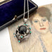 Vintage art nouveau mid century revival necklace with black stone and turquoise stones on a textured surface
