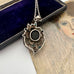 Vintage art nouveau mid century revival necklace with black stone and turquoise stones on a textured surface