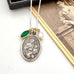 Necklace with a vintage Saint Anne pendant on a white surface next to an old photograph.