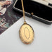 Vintage rolled gold locket on a chain with an open jewelry box in the background