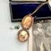Vintage locket with decorative chain on a white surface next to an old photograph.