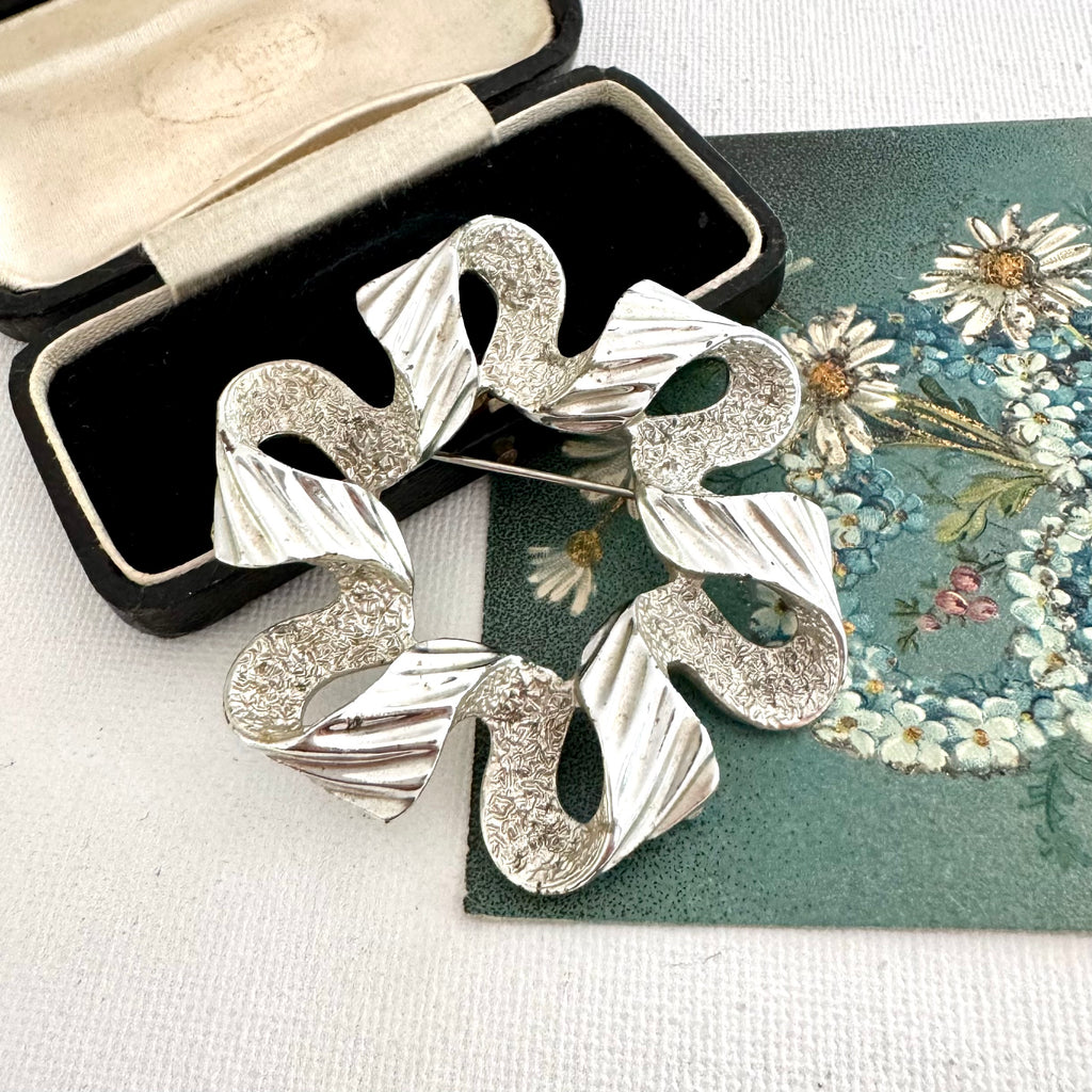 Vintage 1971 silver tone Sarah Coventry ribbonette brooch on an old postcard and with a box