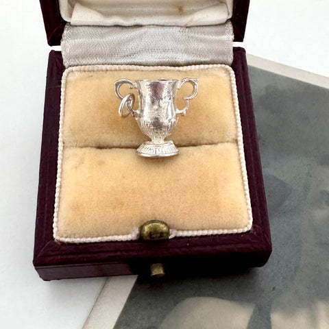 Silver FA Cup trophy-shaped pendant in a jewelry box on a white surface