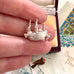 Vintage silver  Mayflower ship charm in a woman's fingers.