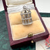Silver birdcage pendant/charm in a jewelry box on a textured surface