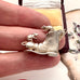 Silver shoe charm with two rats on a finger