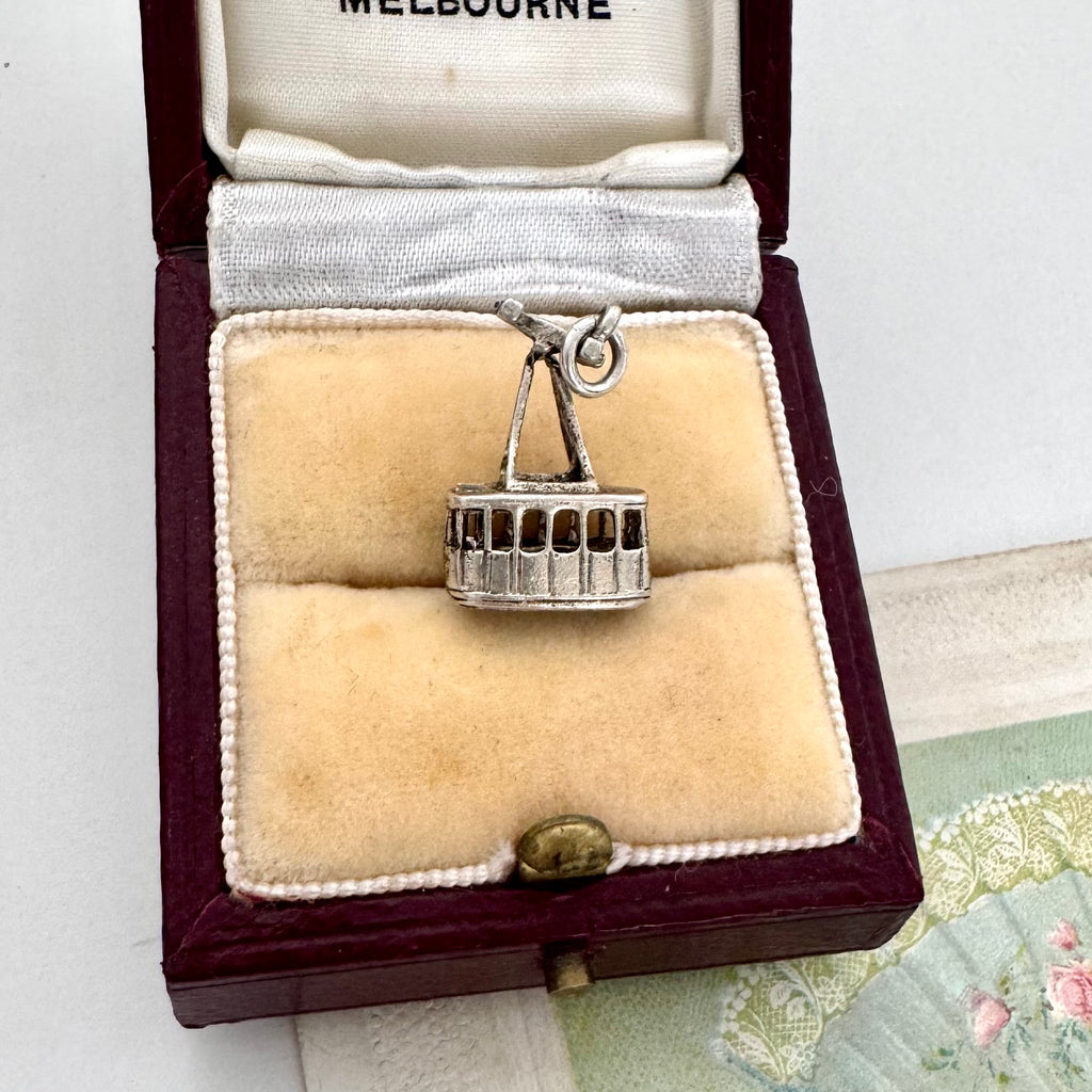 Vintage silver cable car charm in a jewelry box with 'Melbourne' branding