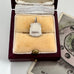 Silver pendant in a jewellery box with vintage photos in the background