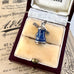 Blue and silver windmill charm in a jewelry box on an old newspaper background