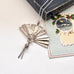 Vintage silver fan necklace on a vintage jewellery box and a vintage Christmas card.