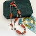 Vintage Middle eastern silver and carnelian chain necklace on a textured green box
