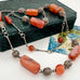 Vintage Middle eastern silver and carnelian chain necklace on a textured green box