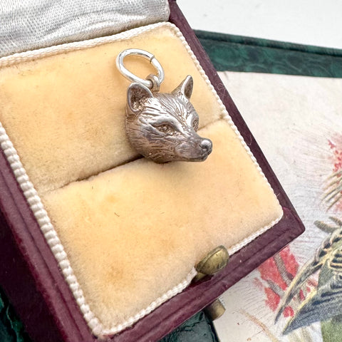 Vintage silver fox charm/pendant in a jewelry box on a floral fabric background