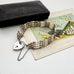 Vintage silver  bar gate bracelet with a heart-shaped padlock charm with an old box and vintage postcard