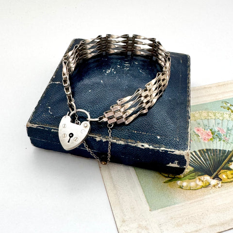 Vintage silver  bar gate bracelet with a heart-shaped padlock charm on an old box