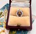 Silver pendant with a deer design in a jewelry box on a decorative surface