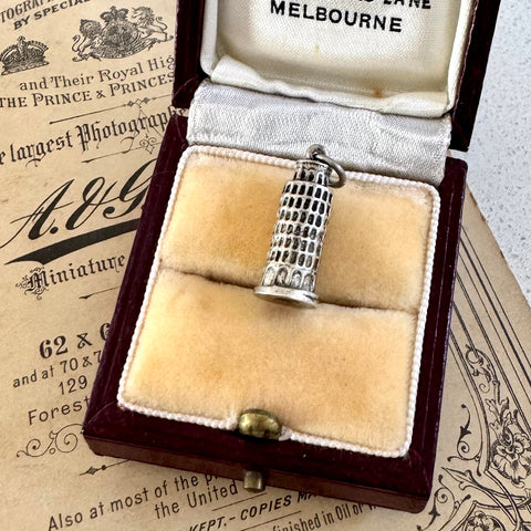Silver  Leaning Tower Of Pisa charm in an open jewelry box with vintage paper in the background