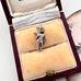 Vintage silver Mexican guitar player charm in a jewelry box with a decorative background
